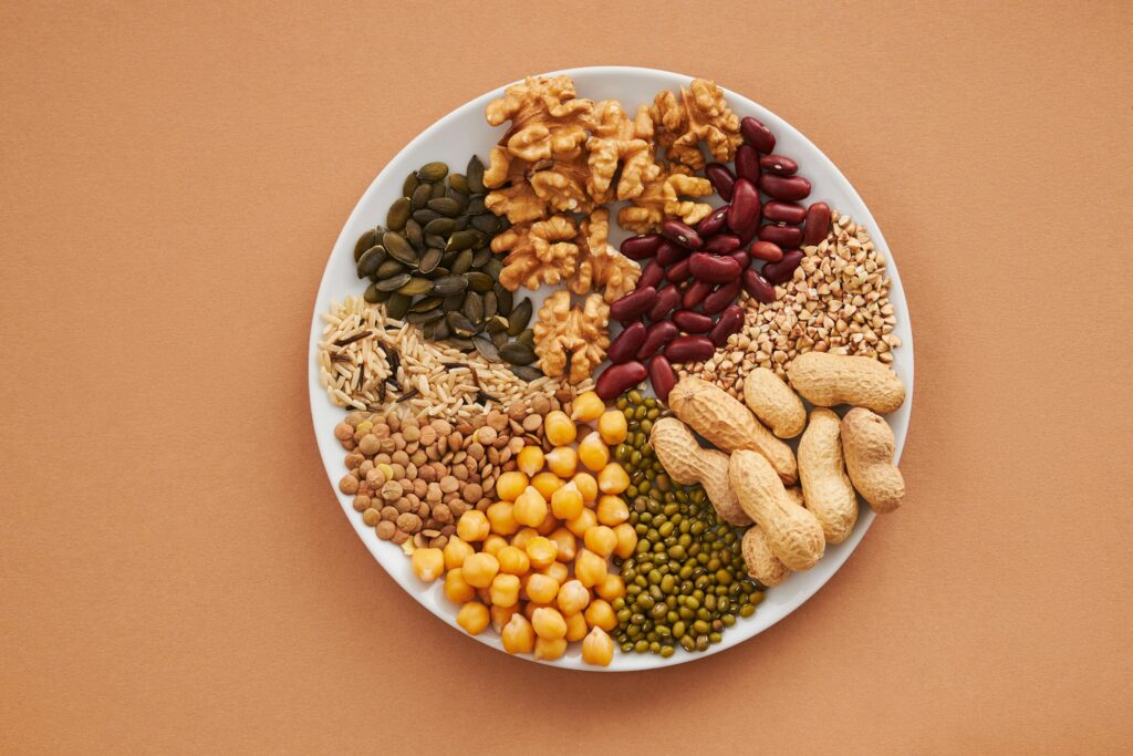 Top view of nuts, beans, and seeds on a plate, ideal for healthy dining themes.